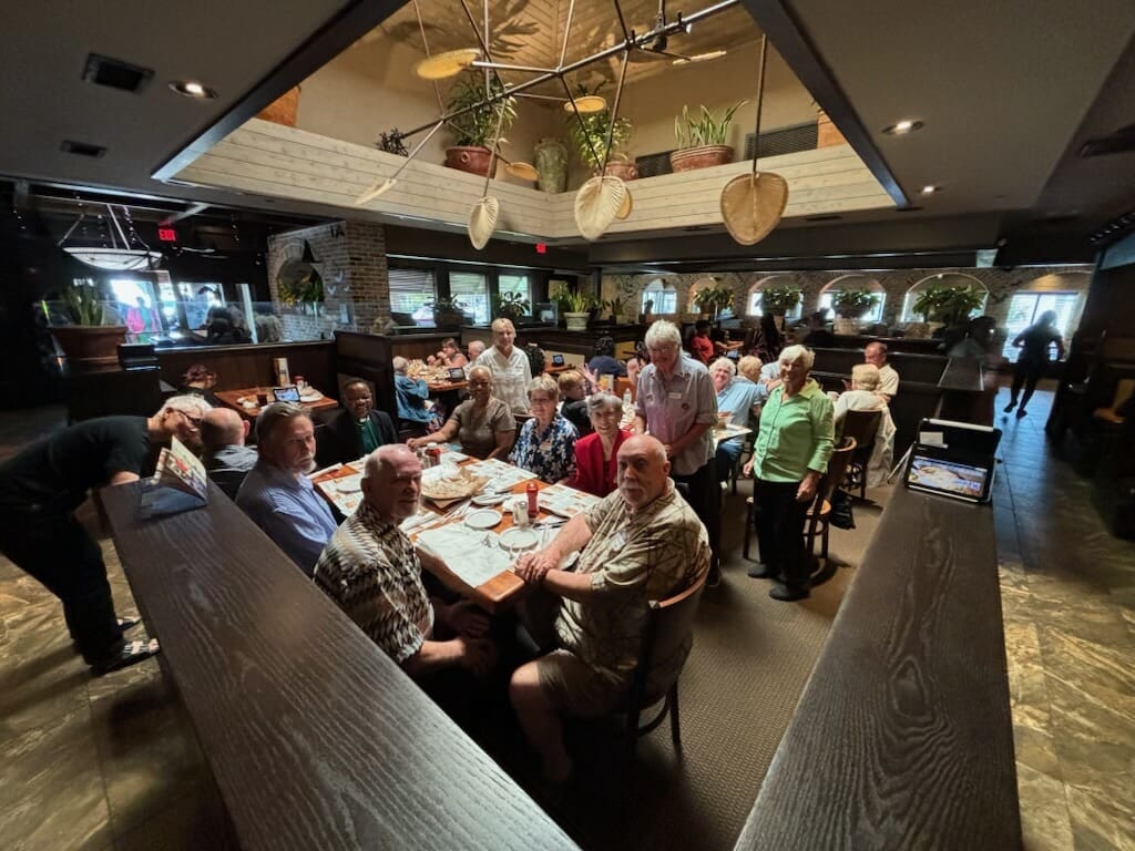 Group enjoying a meal together in a cozy, warmly lit restaurant.